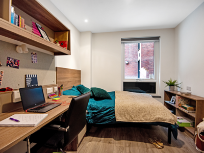 The resident bedroom includes a bed and a study area